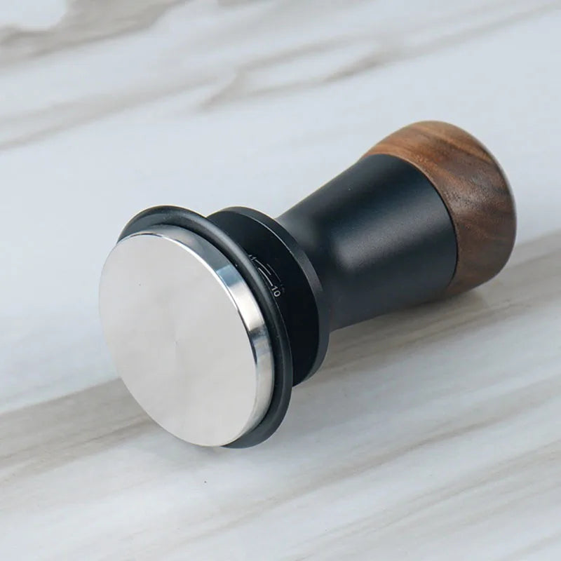 Three-toned object with metallic, black, and wooden finishes on a light wood surface.